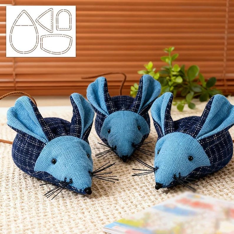 May include: Three blue fabric mouse toys with long whiskers and dark blue plaid ears. The mice are arranged on a textured surface. A pattern for the mice is visible in the upper left corner.