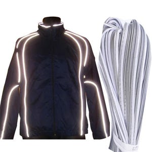 May include: A navy blue jacket with reflective white stripes on the shoulders, sleeves, and torso. Next to the jacket is a bundle of white and gray reflective strips. The jacket has a high collar.