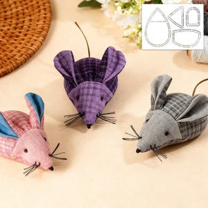 May include: Three fabric mice in pink, purple, and grey with plaid patterns. Each mouse has black whiskers, small black bead eyes, and a long, thin tail. The ears are a contrasting colour. A pattern template is in the background.