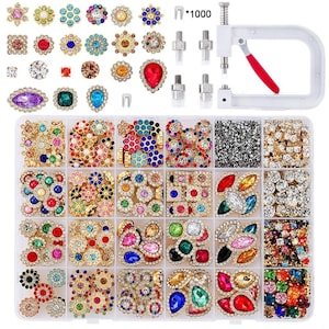 May include: A collection of decorative rhinestone embellishments in various shapes and colors, including flowers, squares, and teardrops. A clear plastic organizer holds the rhinestones, along with a hand press tool and fasteners.