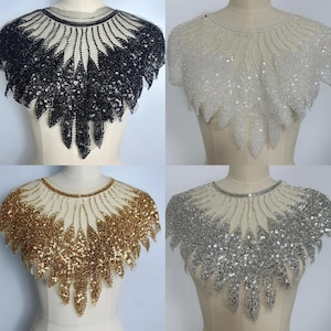 May include: Four beaded collar necklaces in black, white, gold, and silver. Each collar features a round neckline and a detailed, layered design. The collars are displayed on mannequins, showcasing the intricate beadwork and overall design.