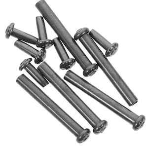 May include: A collection of dark gray metal rivets with decorative, flower-shaped heads. The rivets vary in size and are scattered across a white background. These fasteners are likely used in leatherwork, upholstery, or other crafting projects.