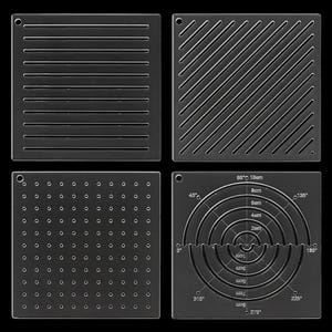Könnte beinhalten: Vier quadratische, transparente Acryl-Schablonen mit verschiedenen Mustern. Eine hat horizontale Schlitze, eine diagonale Schlitze, eine ein Raster aus kleinen Löchern und eine zeigt konzentrische Kreise mit Gradmarkierungen und Maßen bis 10 cm.