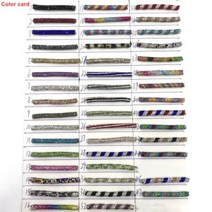 May include: A color card displaying 47 rhinestone trim samples in various colors and patterns. The samples are arranged in rows and columns, with each sample labeled with a number. The text "Color card" is in the upper left corner.