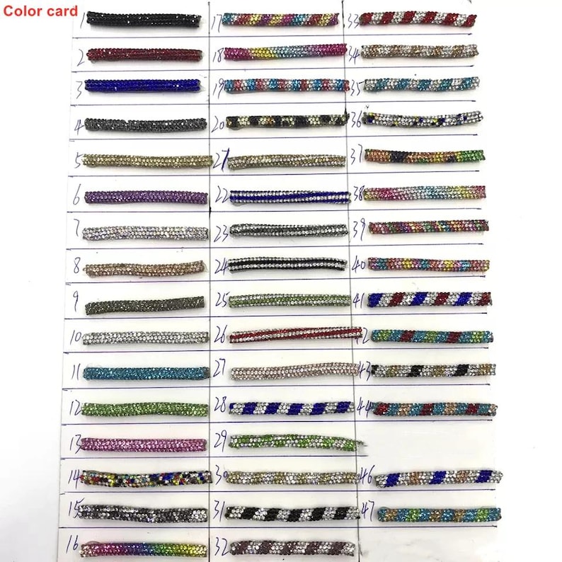 May include: A color card displaying 47 rhinestone trim samples in various colors and patterns. The samples are arranged in rows and columns, with each sample labeled with a number. The text "Color card" is in the upper left corner.