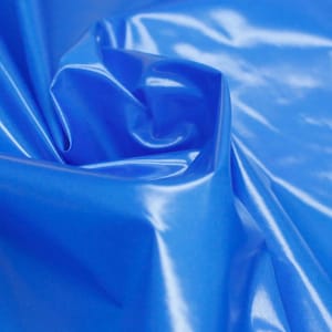 Puede incluir: Una tela azul vibrante con un acabado de alto brillo y reflectante. El material está recogido en pliegues suaves y fluidos que crean sombras profundas y reflejos brillantes sobre la superficie lisa y lustrosa, enfatizando su aspecto líquido.