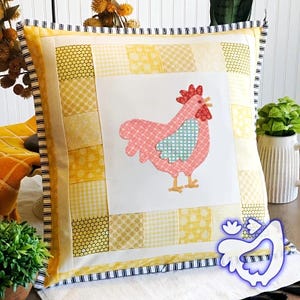 May include: Square cushion with a patchwork design in yellow hues. A central white panel showcases a pink rooster applique with a blue heart. The cushion is trimmed with a striped border, creating a farmhouse style.