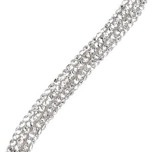 May include: Close-up of a sparkling, silver-toned accessory. The item is densely covered in small, clear crystals, creating a shimmering effect. The design appears to be a strap or band, possibly for a bracelet or necklace, with a diagonal orientation.