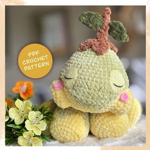 May include: A handmade crochet plush toy in shades of yellow and green, with a brown stem and green leaves. The toy has closed eyes and pink cheeks. A yellow circle with the text "PDF CROCHET PATTERN" is in the image.