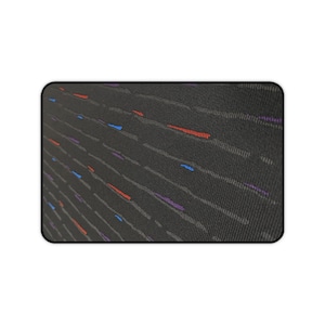 Puede incluir: Alfombrilla de ratón rectangular con fondo negro y un patrón de líneas diagonales grises. Acentos de rojo, azul y morado se intercalan en el diseño, creando una apariencia texturizada.