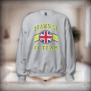 May include: Gray sweatshirt with a yellow and black graphic of the Brawn GP F1 team logo. The logo features a circle with the Union Jack flag and the text "BRAWN GP 2009 F1 TEAM".