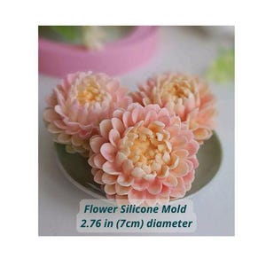 May include: Three flower-shaped silicone molds in shades of pink and yellow, displayed on a small green plate. The text on the image reads "Flower Silicone Mold 2.76 in (7cm) diameter."