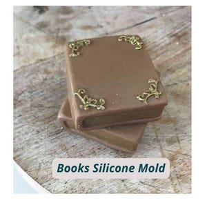 Könnte beinhalten: Zwei braune Silikon-Buchformen, die übereinander gestapelt sind. Die Formen haben goldfarbene Eckverzierungen und goldfarbene Kanten. Der Text "Books Silicone Mold" wird unten im Bild angezeigt.