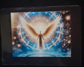 May include: A rectangular print featuring a central figure with large, glowing wings standing before a bright, circular light. The background displays a deep blue cosmic scene with intricate geometric patterns, radiating light, and scattered stars.