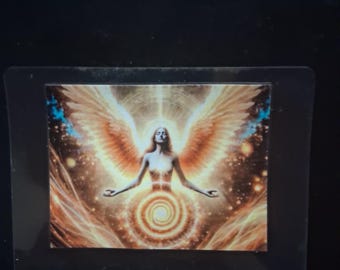 May include: A rectangular sticker featuring a central figure with large, expansive golden wings spread wide. The figure is surrounded by a radiant, glowing light and a prominent golden spiral pattern positioned below the torso, set against a dark background.