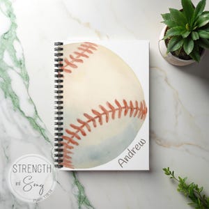 May include: Spiral-bound notebook featuring a watercolor baseball design. The baseball is off-white with red stitching. The name "Andrew" is printed on the notebook. The words "Strength and Song" and "Psalm 118:14" are also printed on the notebook.