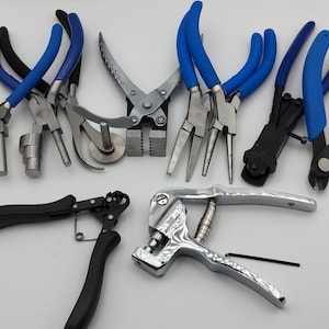 Könnte beinhalten: Eine Sammlung verschiedener Metall-Handwerkzeuge, darunter Zangen und Schneider, mit blauen und schwarzen Griffen. Die Werkzeuge sind auf einer weißen Oberfläche angeordnet und zeigen ihre unterschiedlichen Formen und Größen.