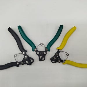 Könnte beinhalten: Drei Gartenscheren mit schwarzen, grünen und gelben Griffen. Die Griffe sind gebogen und ergonomisch, und die Klingen sind aus Metall. Die Scheren sind zum Schneiden von Pflanzen und anderen Gartenarbeiten bestimmt.