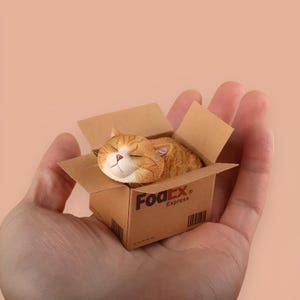 May include: A small orange and white cat is sleeping inside a cardboard box. The box is labeled "FedEx Express".