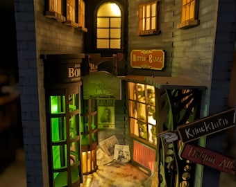 May include: A miniature model of a brick building with a green potion shop, a shop called "Knockturn Alley", and a sign that reads "Ricks Morfin & Sons". The model is lit with warm yellow lights and has a detailed interior.