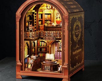 May include: A miniature World Bookstore model with intricate details. The model features a multi-level interior with bookshelves, a reading table, and a small figure. The exterior is brown with gold accents and the text "World Bookstore".