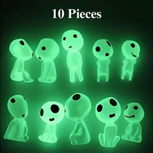 May include: Ten glow-in-the-dark figurines of small, white, humanoid figures with large eyes and rounded features. The figures are arranged in two rows of five. The text "10 Pieces" is printed above the figures.