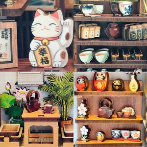 May include: A collage of miniature Japanese-themed items. Includes a white and tan Maneki-neko cat figurine, shelves with tea sets, Daruma dolls, and other decorative objects. The items are arranged on wooden shelves and tables.