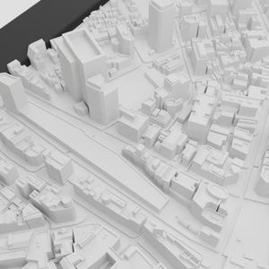 May include: A white 3D model of a city with buildings and streets. The model is made of paper or cardboard and is a miniature representation of a city.