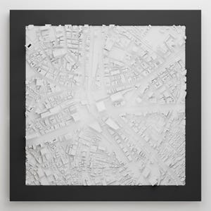 May include: A white 3D model of a city, with buildings and streets, framed in black.