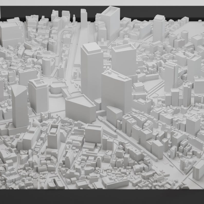 May include: A white 3D model of a city skyline with tall buildings and a street grid.