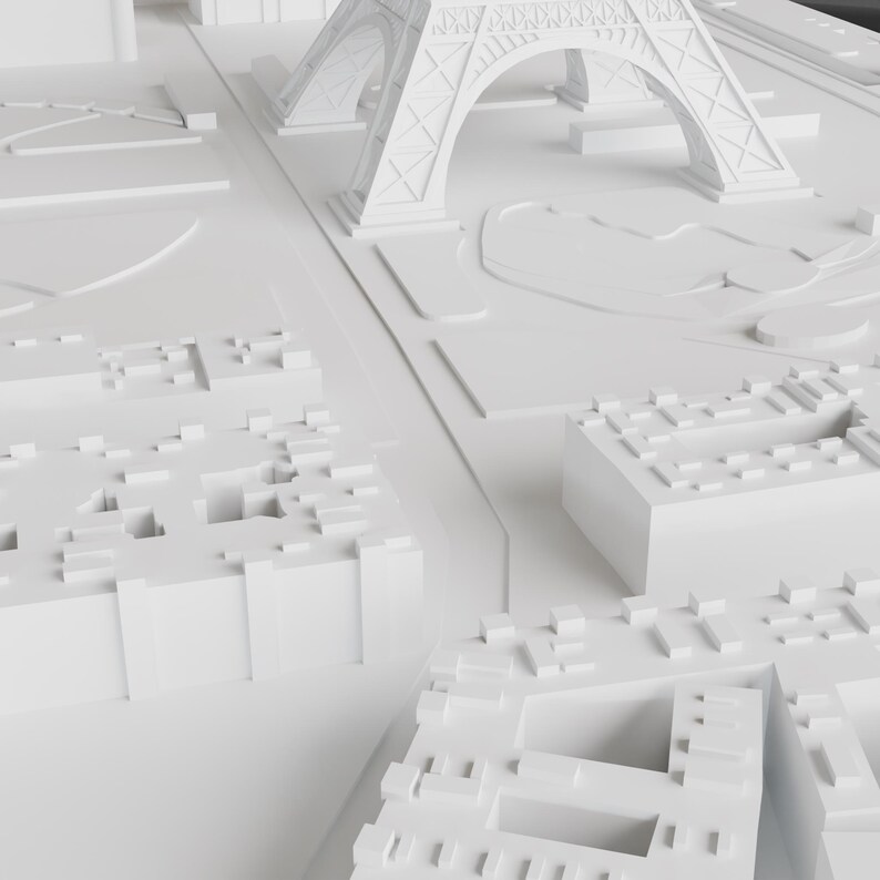 K&ouml;nnte beinhalten: Ein wei&szlig;es 3D-Modell einer Stadt mit einem Miniatur-Eiffelturm im Hintergrund. Das Modell besteht aus kleinen, rechteckigen Bl&ouml;cken, die Geb&auml;ude darstellen. Das Modell steht auf einer wei&szlig;en Oberfl&auml;che.