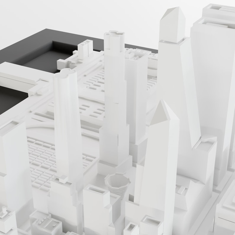 May include: A white model of a city skyline with tall buildings and a black base.