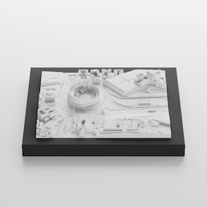 Puede incluir: Un modelo 3D blanco de una ciudad con un gran estadio en el centro. El modelo est&aacute; sobre una base negra.
