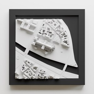 以下が含まれることがあります： 黒いフレームに囲まれた、建物と通りがある街の白い3Dモデルです。