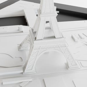 K&ouml;nnte beinhalten: Ein wei&szlig;es Modell des Eiffelturms, ein ber&uuml;hmtes Wahrzeichen in Paris, Frankreich. Das Modell ist aus glattem, wei&szlig;em Material gefertigt und weist komplizierte Details auf. Das Modell steht auf einer wei&szlig;en Oberfl&auml;che.