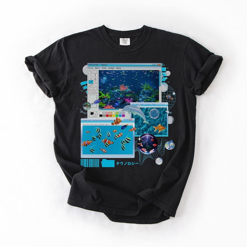 May include: Black t-shirt featuring a graphic design of computer windows displaying an underwater scene with fish and a dolphin. The design includes the Japanese word for technology.