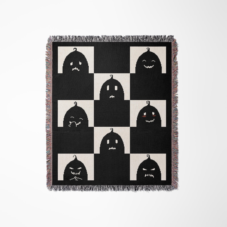 May include: A black and white checkered throw blanket with a pattern of nine black pumpkins with different facial expressions. The pumpkins are arranged in a 3x3 grid.