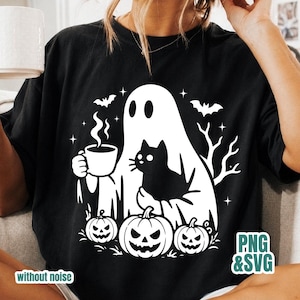 Pode incluir: Uma t-shirt preta com uma estampa gr&aacute;fica branca de um fantasma segurando uma caneca fumegante e um gato preto. O design inclui tr&ecirc;s ab&oacute;boras na parte inferior, dois morcegos voando e galhos de &aacute;rvores secos para uma cena de Halloween.