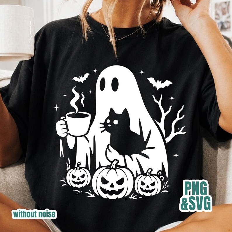Pode incluir: Uma t-shirt preta com uma estampa gr&aacute;fica branca de um fantasma segurando uma caneca fumegante e um gato preto. O design inclui tr&ecirc;s ab&oacute;boras na parte inferior, dois morcegos voando e galhos de &aacute;rvores secos para uma cena de Halloween.