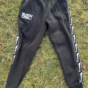May include: Black sweatpants with white side stripes and the text "BLACK CARL!" embroidered on the left leg.