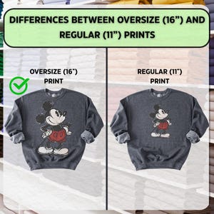 Puede incluir: Dos sudaderas grises oscuras con dise&ntilde;os de Mickey Mouse. La sudadera izquierda tiene una impresi&oacute;n m&aacute;s grande de 40 cm, mientras que la derecha tiene una impresi&oacute;n regular de 28 cm. El texto en la parte superior dice "DIFFERENCES BETWEEN OVERSIZE (16") AND REGULAR (11") PRINTS."