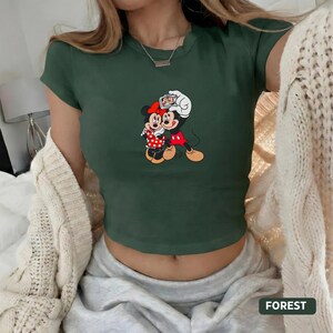 May include: A white ceramic mug with a black handle and the text "But First, Coffee" in a black, bold font. The mug is on a white surface.