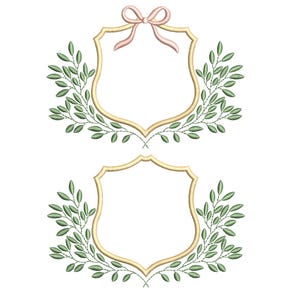 Puede incluir: Dos marcos bordados con borde dorado y forma de escudo. Hojas verdes y un lazo rosa adornan el marco superior. Ideales para proyectos de bordado, invitaciones o diseños decorativos.
