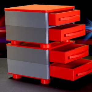 May include: A stackable storage unit with four drawers. The drawers are red with gray trim and have a handle on the front. The unit is made of plastic and has a gray base.
