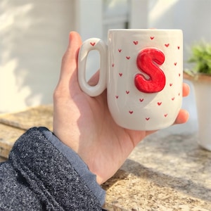 Taza personalizada con inicial y corazones rojos. Regalo personalizado para ella o para él. Bonita taza con letras. Regalo de San Valentín o cumpleaños. Cerámica hecha a mano.