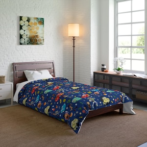 May include: A dark blue single duvet cover featuring a repeating pattern of various animated characters from the Toy Story and Cars film franchises, including Lightning McQueen, Buzz Lightyear, and Woody, scattered across the fabric surface.