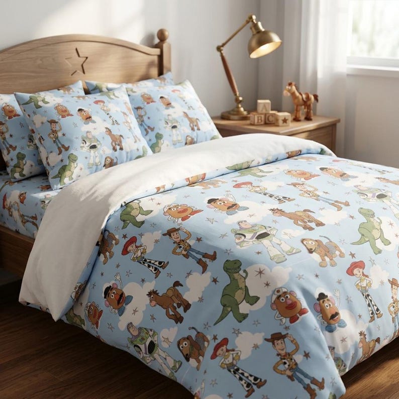 Puede incluir: Un juego de cama azul claro con un patr&oacute;n repetitivo de varios personajes de dibujos animados, incluyendo un vaquero, un guardi&aacute;n espacial, un dinosaurio verde, una figura con forma de patata y un caballo marr&oacute;n, entre nubes y estrellas.