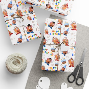 May include: Gift-wrapped presents with white wrapping paper featuring a repeating pattern of cartoon characters, birthday cakes, stars, and the words "Happy Birthday." The gifts are tied with twine and have blank heart-shaped tags.