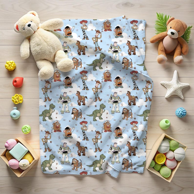 K&ouml;nnte beinhalten: Eine hellblaue Decke mit einem sich wiederholenden Muster aus Zeichentrickfiguren, darunter ein Cowboy, ein Weltraum-Ranger, ein Dinosaurier, eine kartoffelf&ouml;rmige Figur und ein Hund, durchsetzt mit wei&szlig;en Wolken und kleinen Sternen.
