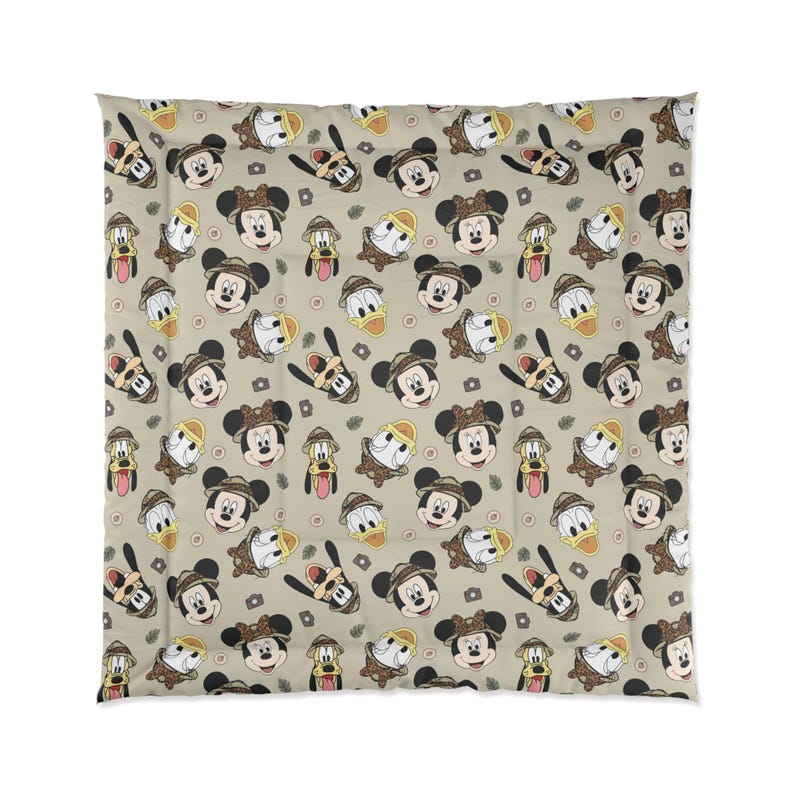 Pu&ograve; includere: Un piumino beige con un motivo ripetuto di Topolino, Paperino e Pluto in tenuta da safari. Il design include fotocamere e foglie, creando un set di biancheria da letto a tema avventura.
